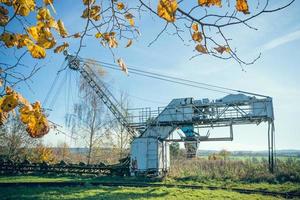 Large crane machine abandoned in field photo