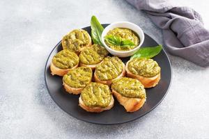 Sandwiches with pesto sauce, fresh basil leaves and garlic. A delicious healthy snack copy space photo