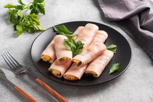 Ham and cheese rolls on a plate. Delicious appetizer meat carbonate and cream cheese. photo