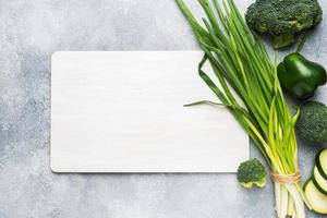 Frame Fresh green vegetables and herbs on a grey concrete background. Copy space. photo