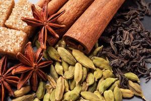 Whole grains of cardamom, a stick of cinnamon star anise and cane sugar. Copy space. Ingredients for making the Indian drink masala tea. photo