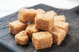 A few cubes of cane sugar on a wooden stand. Copy space. photo