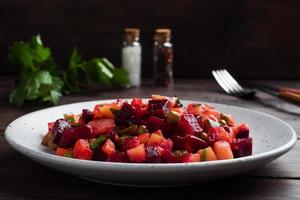 Vinaigrette with beetroot and boiled vegetables, traditional Russian homemade salad. Dark wooden background, copy space. photo