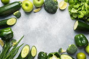 Frame Fresh green vegetables and herbs on a grey concrete background. Copy space. photo