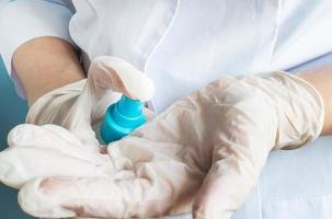 A nurse disinfects hands in latex medical gloves with a cleaning solution. photo