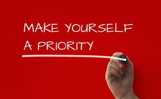 Inspirational quote text on red cover background - Make yourself a priority. photo