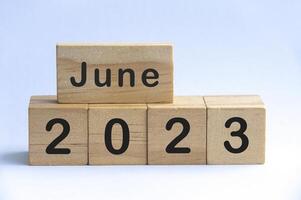 June 2023 text on wooden blocks with white color background. Copy space photo