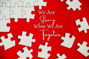 Text on missing jigsaw puzzle - We are strong when we are together. photo