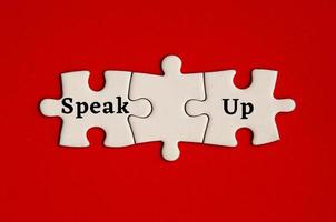Text on missing jigsaw puzzle - Speak up. With red background. photo