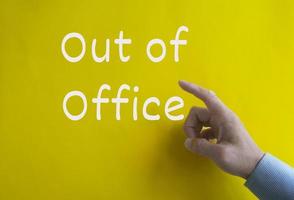 Out of office text on yellow cover background. Business and out of office concept photo