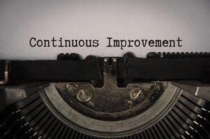 Continuous improvement text on an old typewriter in vintage color. Business concept photo