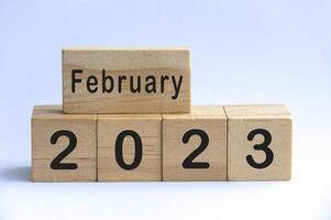 February 2023 text on wooden blocks with white color background. Copy space and month concept photo