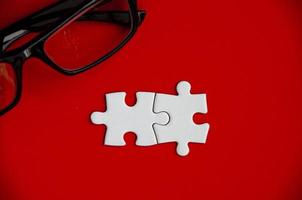 Top view of missing jigsaw puzzle with glasses. Conceptual photo