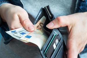 Women's hands take money euro out of their wallets. photo