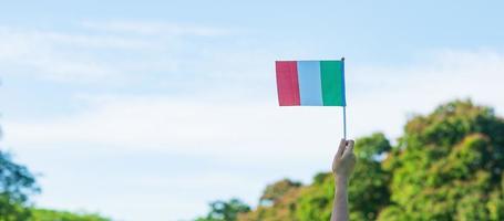 hand holding Italy flag on nature background. National Day, Republic Day, Festa della Repubblica and happy celebration concepts photo