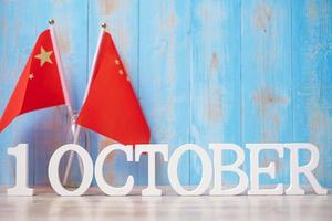 texto de madera del 1 de octubre con banderas chinas. día nacional de la república popular de china, día festivo de la nación pública y conceptos de celebración feliz foto