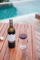 Red wines glasses near swimming pool. Summer travel, vacation, holiday and happy weekend concept photo