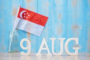 texto de madera del 9 de agosto con banderas en miniatura de singapur. día de la independencia de singapur, día nacional del estado de la ciudad y feliz celebración conceptos de república foto