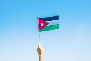 hand holding Jordan flag on nature background. Jordan Independence day and happy celebration concepts photo