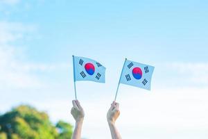 hand holding Korea flag on nature background. National Foundation, Gaecheonjeol, public Nation holiday, National Liberation Day of Korea and happy celebration concepts photo