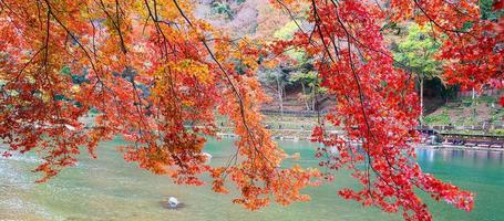 montañas de hojas coloridas y río katsura en arashiyama, hito del paisaje y popular para las atracciones turísticas en kyoto, japón. otoño temporada de otoño, vacaciones, vacaciones y turismo concepto foto