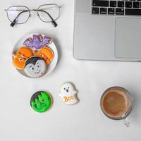 Halloween Cookies,  hot coffee and computer laptop on white background. Happy Halloween, online shopping, Hello October, fall autumn, Festive, party and holiday concept photo