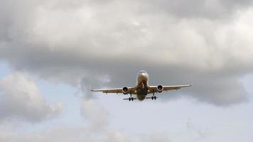 Airliner in the evening sky on final approach in a cloudy sky background, before landing on a runway. video