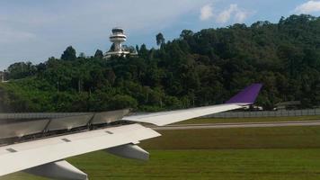 vue sur la piste et la tour de contrôle de l'aéroport international de phuket, depuis un avion au sol