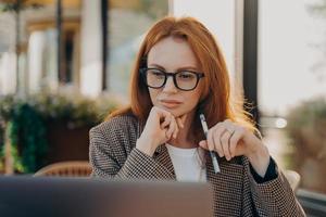 Experienced businesswoman in elegant clothes watches video about creating startup photo