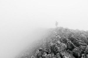 Black and white hiker on a foggy mountain photo