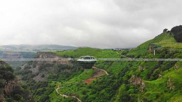 dashbashi, georgia, 2022 - volo aereo sopra la piattaforma a forma di diamante sul ponte di vetro sulla pittoresca valle di dashbashi nella campagna georgiana. famoso ponte moderno sulla valle nel Caucaso video