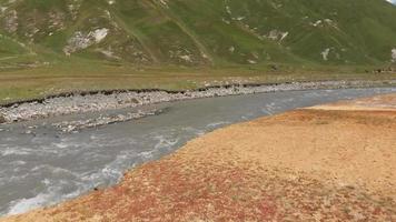 flygfoto stigande utsikt över truso dalen landskap med floden och kazbegi bergen bakgrundsvy video