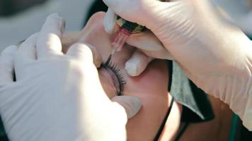 maestro del maquillaje permanente crea cejas para el cliente de una mujer. tatuaje de ceja de cerca. marcar y crear cejas con maquillaje permanente video