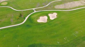 sorvolando un campo da golf. prato verde come un campo da golf con piste. video