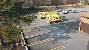 chicago illinois 12.04.2022 krankenwagen auf dem parkplatz der notaufnahme des krankenhauses. Luftaufnahme mit Zoom von drei gelben Krankenwagen, die für die Abreise aus dem Krankenhaus vorbereitet sind video