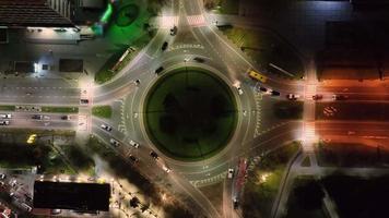 aerila ve el tráfico de autos moviéndose en una rotonda por la noche. ciudad nocturna y tráfico de autos moviéndose en círculo. video