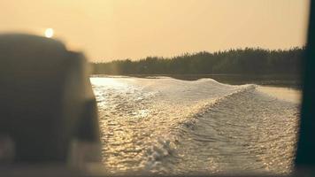 Beautiful view from a motor boat on the waves at sunset. A trip on a motor boat at sunset video