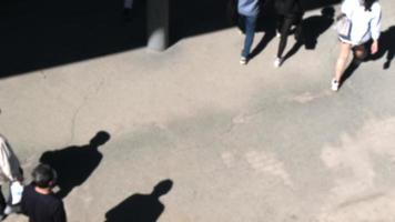 Blurred walking people from high angle view on a sunny spring day. Shadows of people are strong and beautiful. video