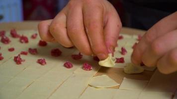 fabrication de manti à la main. repas turc. la femme qui met la viande hachée entre les raviolis, serre les raviolis dans sa main. plat turc traditionnel, raviolis. video