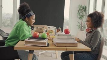 African American students talking happily while sharing with thoughts in study room. video