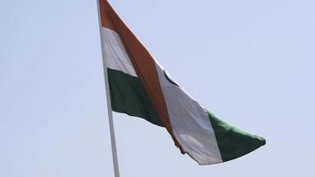 indiase vlag hoog op connaught plaats met trots in de blauwe lucht, indiase vlag wapperen, indiase vlag op onafhankelijkheidsdag en republiek dag van india, tilt-up shot, wuivende indische vlag, vliegende indiase vlaggen video