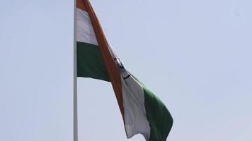 indiase vlag hoog op connaught plaats met trots in de blauwe lucht, indiase vlag wapperen, indiase vlag op onafhankelijkheidsdag en republiek dag van india, tilt-up shot, wuivende indische vlag, vliegende indiase vlaggen video