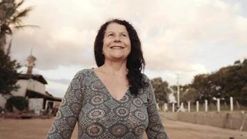 leende latin brasiliansk kvinna på gården. glädje, positiv och kärlek. filmisk 4k video