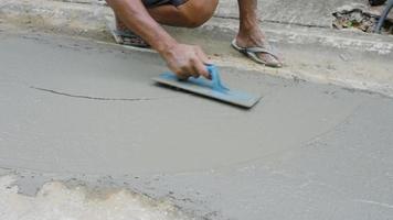 Nahaufnahme von Arbeitern, die Beton nivellieren und glätten, um die Straße zu reparieren video