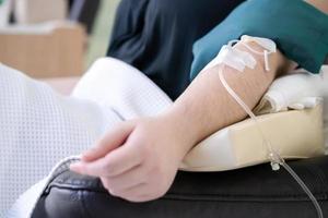 cerca del brazo asiático que recibe vitamina de la clínica de atención de la mujer. foto