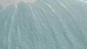 bem-vindo ao México. a inscrição no fundo de areia, que é levada pelas ondas do mar. protetor de tela. ondas lavam a areia. fundo do mar arenoso através de águas claras. video