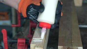carpintero aplica pegamento a la pieza de trabajo con una serpiente video