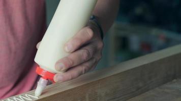 woodworker applies glue to the workpiece with a snake video