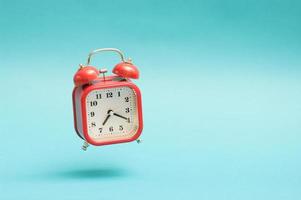 Flying red vintage style analog alarm clock. photo