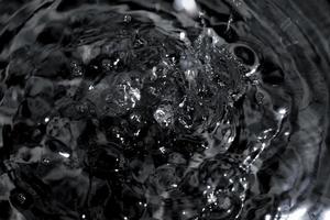 Abstract black water surface background. Dark splashes abstract background. photo